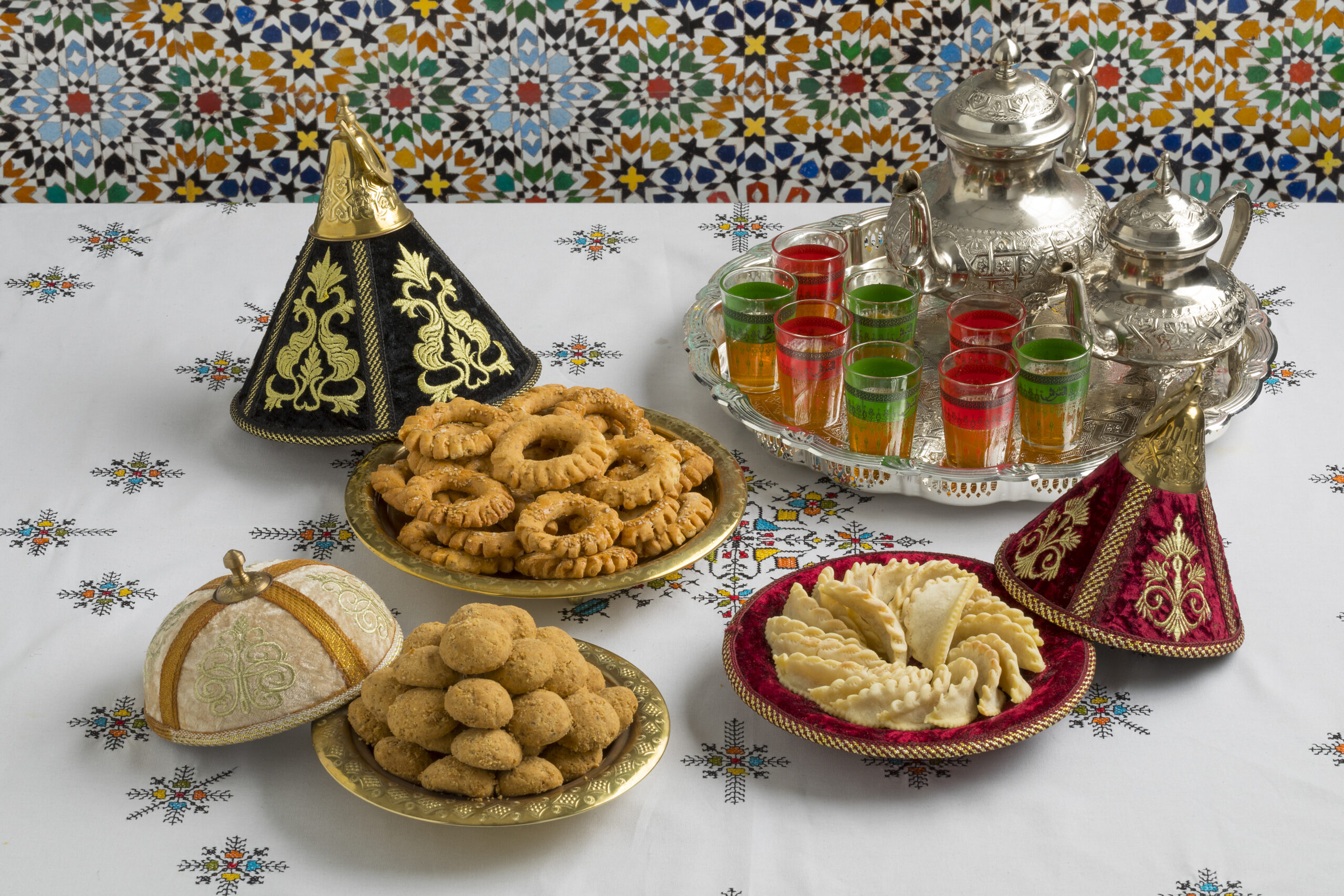 Traditional Moroccan cookies in a festive tajine Traditional Moroccan homemade cookies in festive metal tajines on an embroidered tablecloth